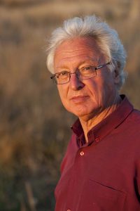 Raimond Gaita in the afternoon light standing in an Australian pasture.