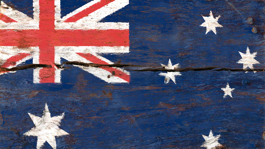 An Australian flag painted on a weathered wooden board, which has cracked across the middle.