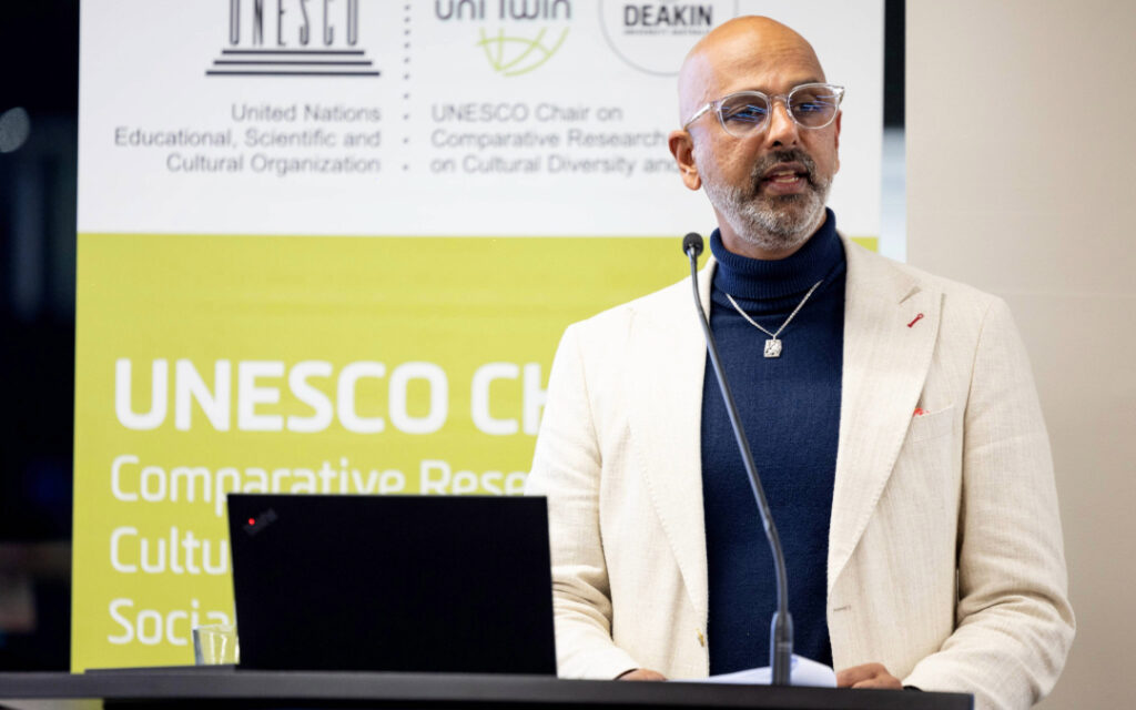 A close up of giridharan Sivaraman at the podium, delivering the UNESCO Chair Oration 2024 on Racism.